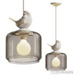 Two pendant light fixtures featuring clear glass shades with a white bird perched on top and an illuminated yellow light bulb inside.