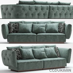 A three-seater teal velvet sofa with button tufting on the backrest and two patterned throw pillows on each end.