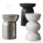 Three modern stools in different finishes: one in silver metal, one in black, and one in white, all with rounded tops and bases.