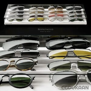 A display of various designer sunglasses on glass shelves with the text "BESPECTACLED model by Aviato" at the bottom.